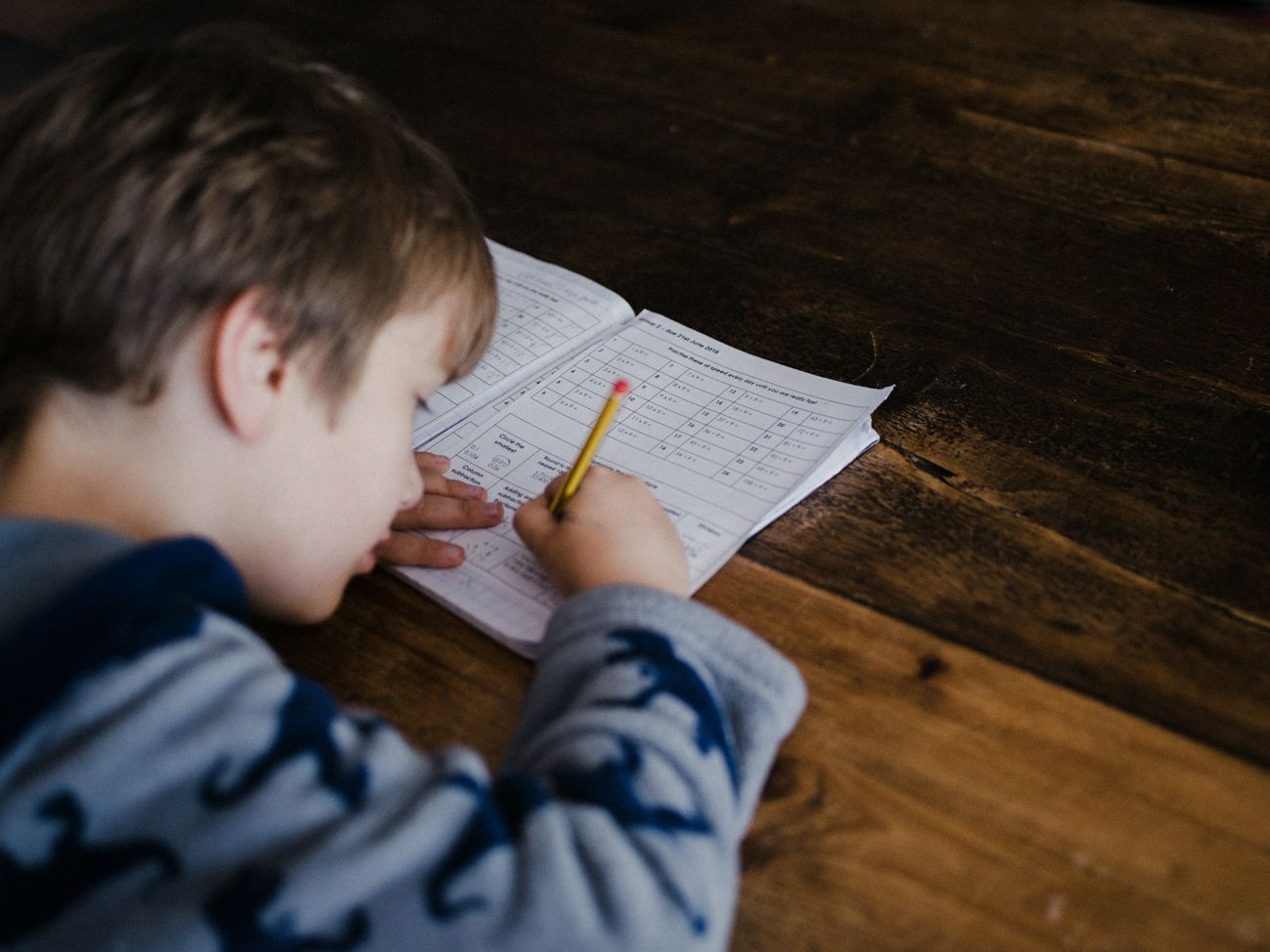 Un garçon résout des exercices de mathématiques dans son cahier